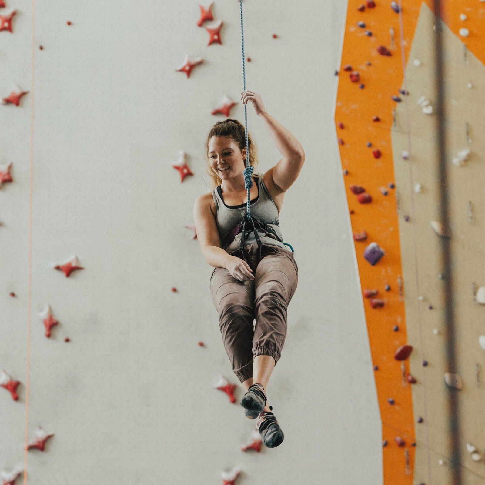 person going down rock climbing wall